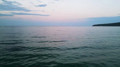 Tranquil Sea Sunset with Calm Waves and Coastal Silhouette Stock Footage 340548956