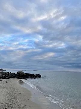 Tranquil Seashore Under a Cloudy Sky Stock Photos