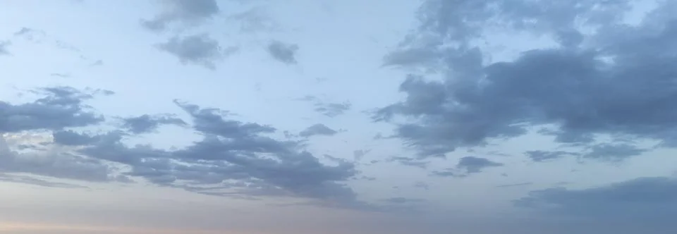 Tranquil sky at dusk showcasing a gradient of soft blue and grey hues, with Stock Photos