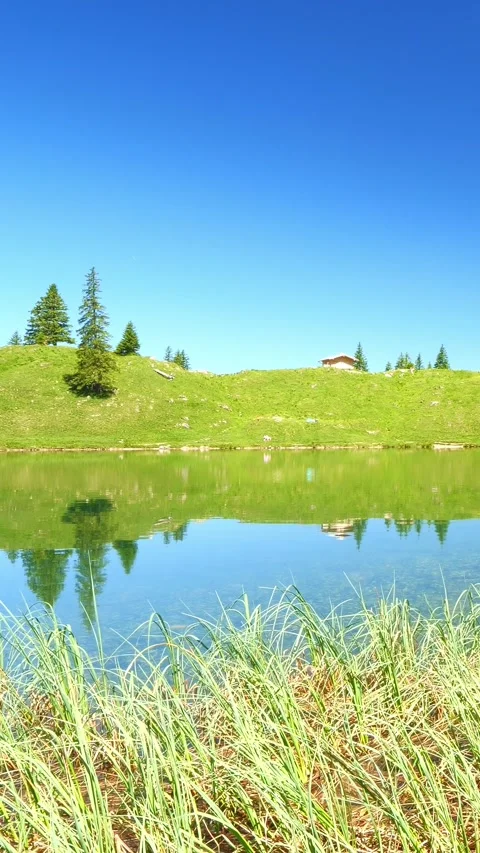 Tranquil Spring Reflections at Geisalpsee in Allgu: Serene Lake Views, Lush G Stock Footage 309231468