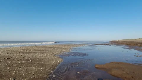 Tranquil summer 4K beach scene, showcasing the serene flow of crystal-clear.. Stock Footage 252397047