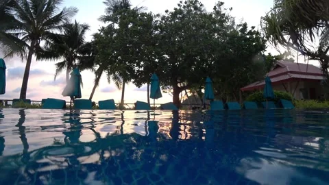 Tranquil sunrise reflecting on infinity pool water surface Video stock 306739589