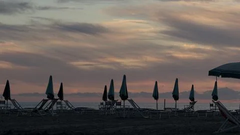 Tranquil Sunset on a Closed Beach with Umbrellas Stock Photos