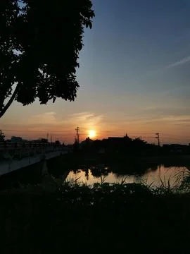 Tranquil Sunset Over Bridge and River Reflection in Rural Landscape Stock Photos