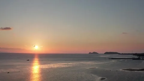 Tranquil sunset over calm ocean with a small boat and distant islands Stock Footage 309336460