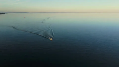 Tranquil Sunset Over Calm Sea with Small Boat Stock Footage 285928835