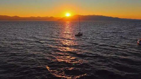 Tranquil Sunset Over a Large Lake with a Sailboat and Mountain Horizon China Stock-Footage 346931223