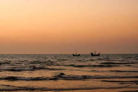 Tranquil Sunset Over Ocean Waves With Boats on the Horizon Stock Photos