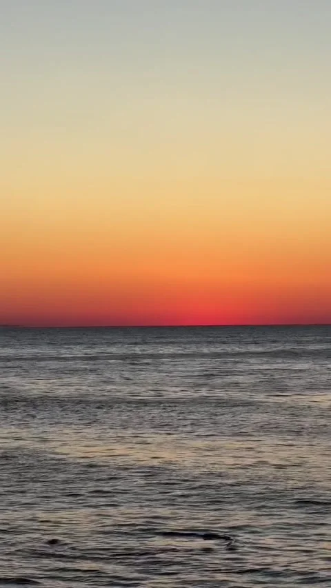 Tranquil Sunset Over Open Ocean with Distant Cargo Ship Vidéo 339882913