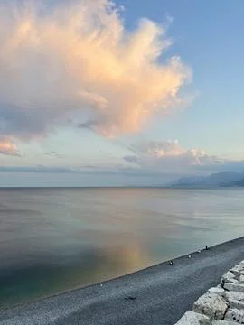 Tranquil Sunset Over Pebble Beach and Calm Sea Foto stock