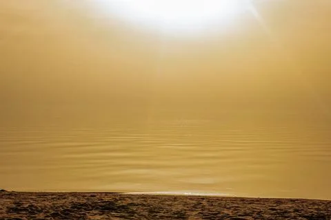 Tranquil sunset over a smooth beach shoreline with gentle waves and golden. Fotos Stock
