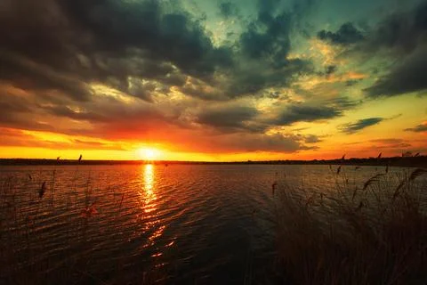 Tranquil sunset over the water with stunning cloud formations Stock Photos