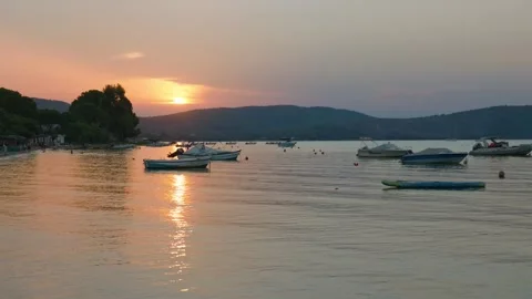A tranquil sunset scene at Vourvourou Beach in Halkidiki, Greece, showing small Stock Footage 346681229