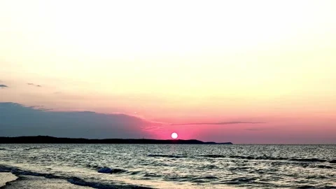 Tranquil sunset seascape with low sun above calm horizon, gentle waves, distant Video stock 343628722