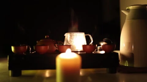 A tranquil tea setup with a steaming Yixing clay teapot, a glass teapot, and cla Video stock 299385359