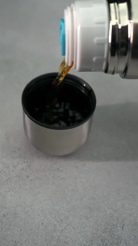 Tranquil Tea Time: Pouring from Thermos Against Neutral Background Stock Footage 267625595