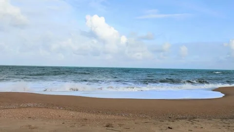 Tranquil Tropical Beach with Gentle Waves Rolling Beneath Cloudy Sky Horizon Stock Footage 319379399
