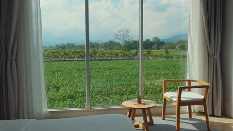 Tranquil view from bedroom window overlooking lush green fields and Видео 286247589