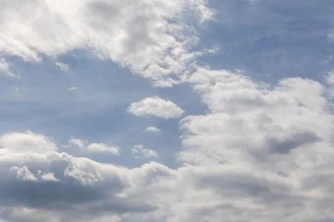 A tranquil view of a blue sky filled with scattered white and gray clouds on a Foto stock