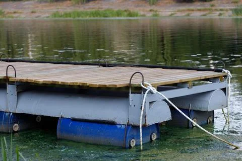 A Tranquil View of a Floating Dock on Calm Waters Surrounded by Lush Greenery in Stock Photos