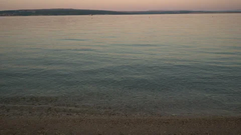 A tranquil view of gentle ripples washing onto a pebble shore along the Adr.. Stock Footage 341955985
