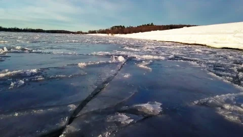 Tranquil View Of Ice Floating On Lake In Winter By Forest During Sunny Day - Stock Footage 233999198