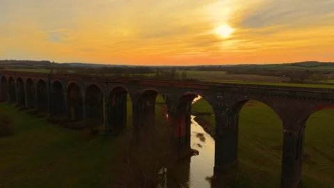 Tranquil view of railway bridge wrapped in golden dusk. Scenic train bridge seen Stock Footage 309639408