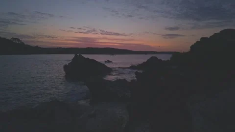 Tranquil Water seascape featuring rocks and hills at sunrise near Looe Cornwall Stock Footage 336925890