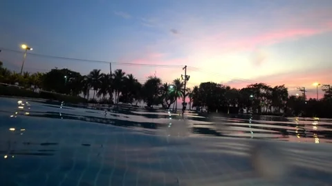 Tranquil water surface reflecting a vibrant sunset over tropical trees Video stock 306739521