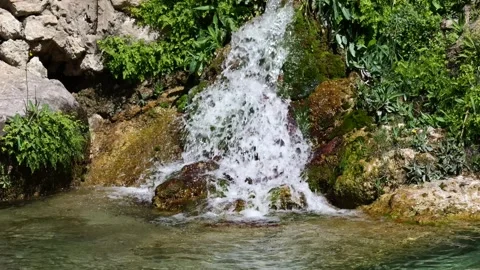 Tranquil waterfall cascading over moss-covered rocks . Close-up Stock Footage 305031923