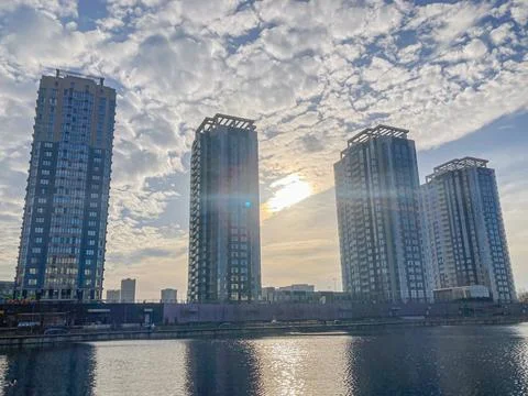 A tranquil waterfront scene featuring three modern, glass and metal high-rise Foto stock