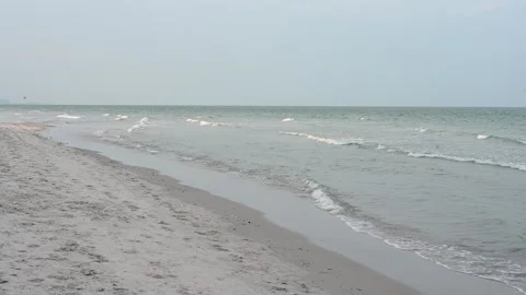 Tranquil waves caressing sandy beach under cloudy sky Vídeo Stock 281790300