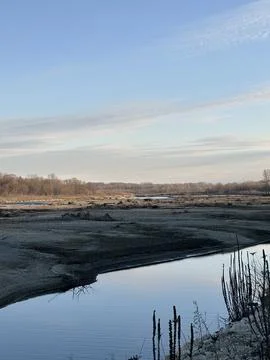 Tranquil Winter River with Reflections and Bare Shoreline Stock Photos
