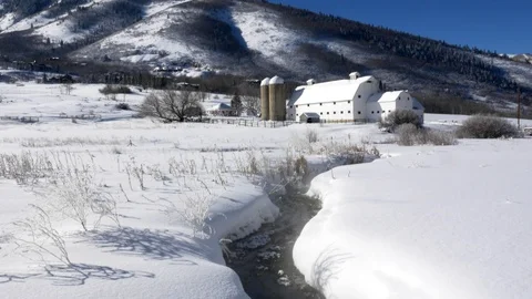 Tranquil winter scene of historic white barn with creek, Park City, Utah. Stock Footage 99993847