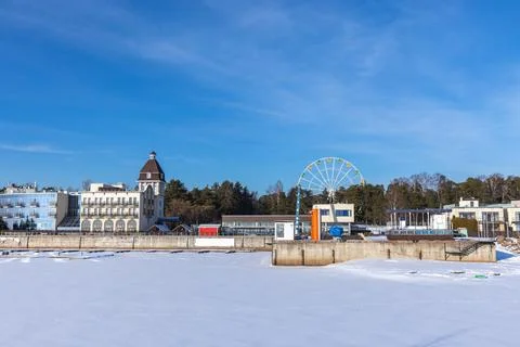 A tranquil winter waterfront scene features a large Ferris wheel, modern bu.. Stock Photos