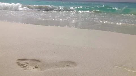 Tranquility and inspiration on island beach showing a footprint Stock Footage