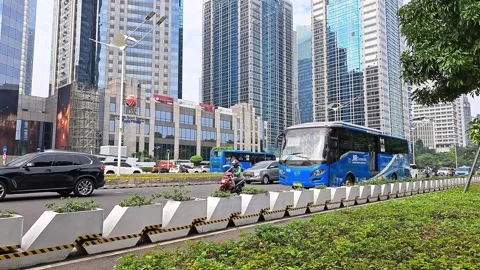 The Trans Jakarta bus passes between the busy traffic Stock Footage 240812520