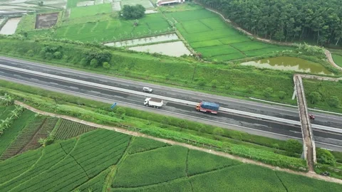 Trans-Java highway slash into extensive paddy rice cultivation area Stock Footage 277104742
