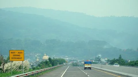 Trans Java toll road during the day, faint background of hills Stock Photos