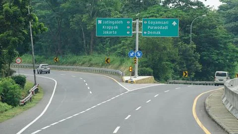 Trans Java toll road at noon. There are signs for the city of Jakarta, Purw.. Stock Photos