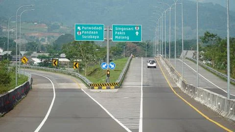 Trans Java toll road at noon. There are signs for the city of Surabaya, Mal.. Stock Photos