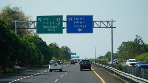 Trans Java toll road at noon. There are signs for the city of Surabaya, Ban.. Stock Photos