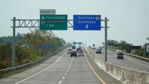 Trans Java toll road at noon. There are signs for the city of Surabaya, Pan.. Stock Photos