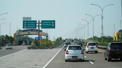 Trans Java toll road at noon. There are signs for the city of Surabaya, Ban.. Stock Photos