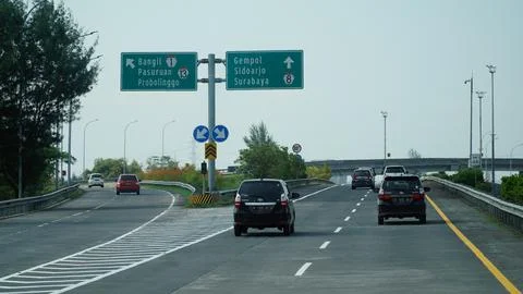 Trans Java toll road at noon. There are signs for the city of Surabaya, Ban.. Stock Photos
