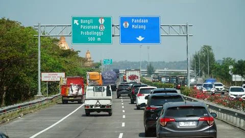 Trans Java toll road at noon. There are signs for the city of bangil, Probo.. Stock Photos