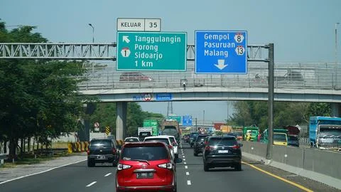 Trans Java toll road at noon. There are signs for the city of Sidoarjo, Por.. Stock Photos