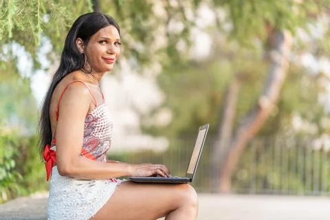 Trans woman smiling at the camera while working in remote Foto stock