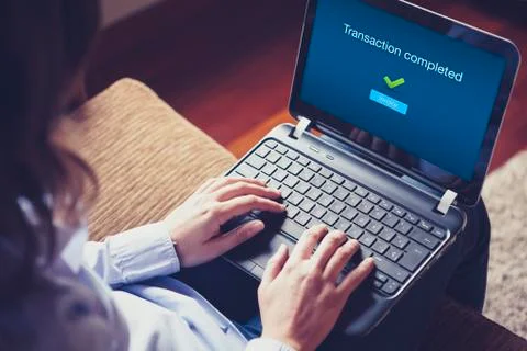"Transaction completed" on a laptop screen. Hands over the keyboard on laptop. Stock Photos