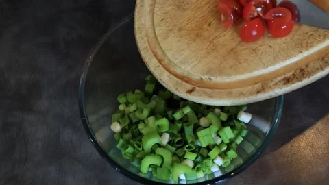 Transferring Chopped Cheery Tomatoes from Chopping Board to Glass Bowl Stock Footage 304368660